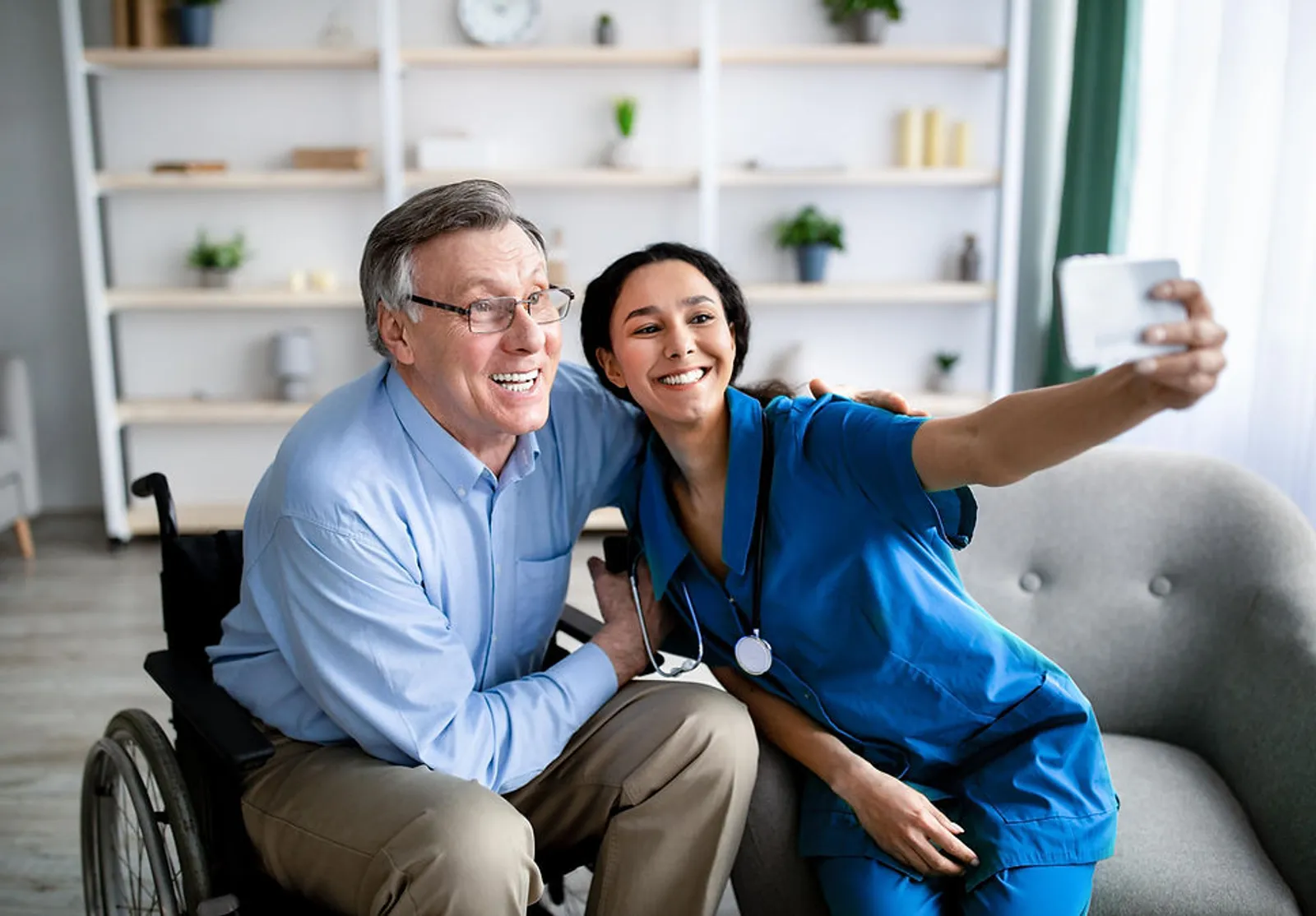 Senior in a wheelchair smiling with a Pulse Home Health caregiver
